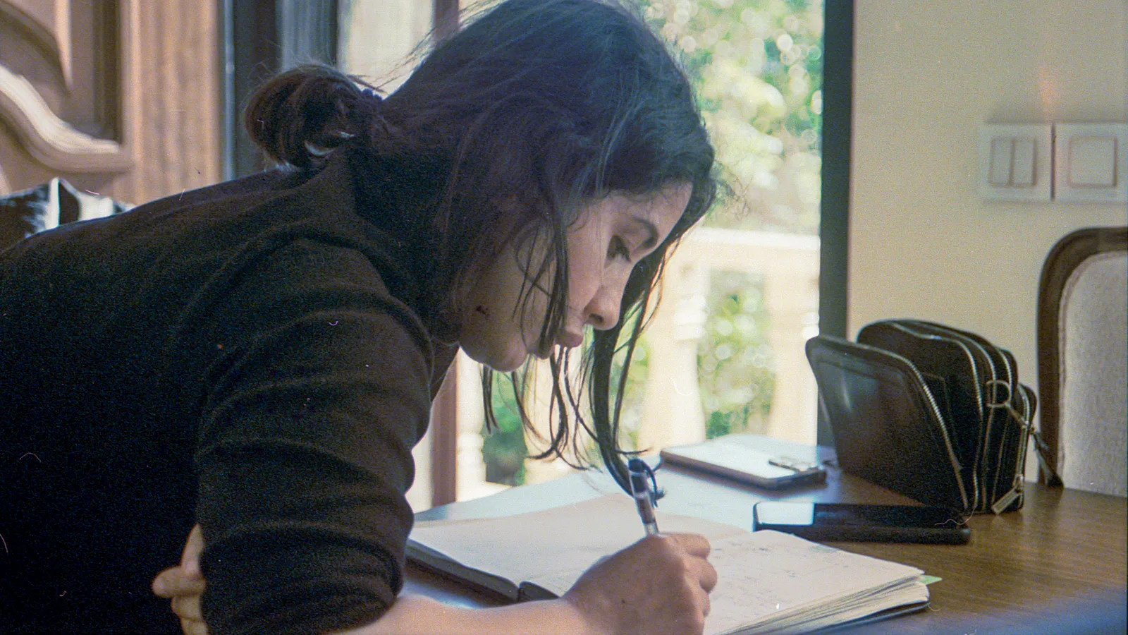 Woman writing in a notebook while planning how to complete a discontinued degree Woman writing in a notebook while planning how to complete a discontinued degree